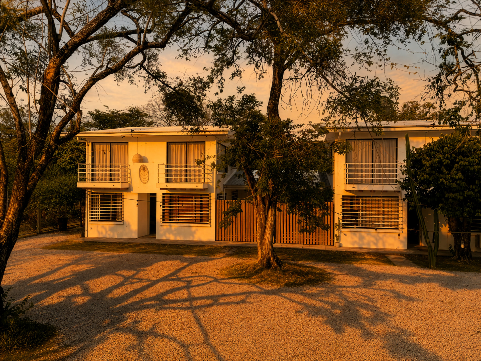 Las dos casas de Casa Buda Liberia con luz dorada al atardecer